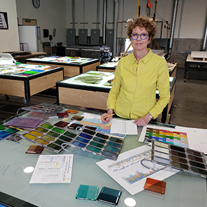 Laurie Frick in her studio working with glass sample